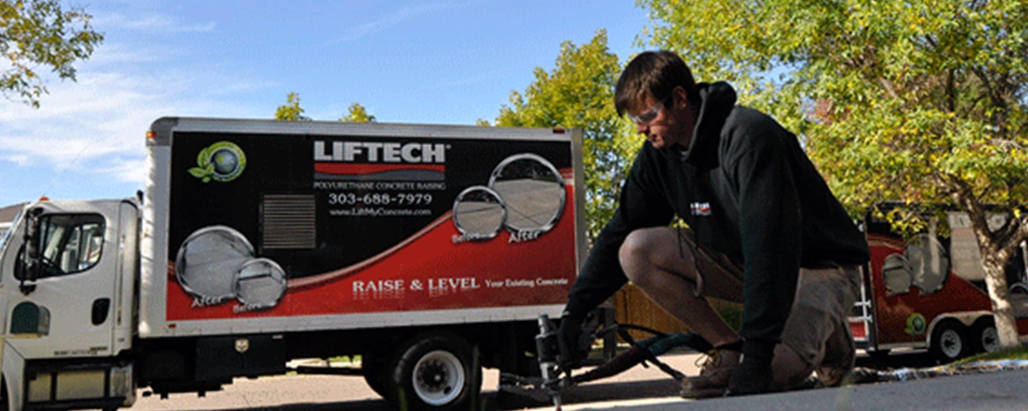 A Liftech technician injecting foam under a concrete slab beside a Liftech truck
